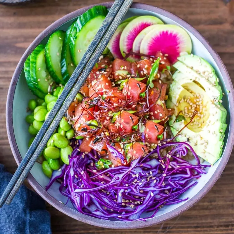 Spicy Tuna Deluxe — Verse tonijn, romige avocado, knapperige edamame, komkommer, sesamzaad en onze huisgemaakte spicymayo. Een klassieker met pit.